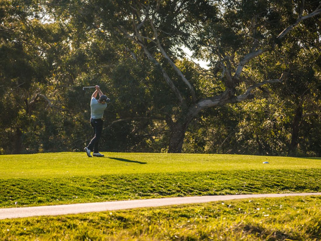 A golfer on the course at Newcastle Golf Club, late afternoon